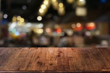 Empty dark wooden table in front of abstract blurred boken bankground of restaurant. Can used for...