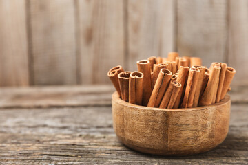 Cinnamon sticks on a textured wooden background. Cinnamon roll. Spicy spice for baking, desserts and drinks. Fragrant ground cinnamon. cinnamon powder Close-up. Place for text. copy space