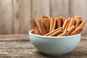 Cinnamon sticks on a textured wooden background. Cinnamon roll. Spicy spice for baking, desserts and drinks. Fragrant ground cinnamon. cinnamon powder Close-up. Place for text. copy space