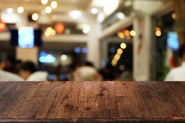 Empty dark wooden table in front of abstract blurred boken bankground of restaurant. Can used for display or montage your products. Mock up for space.