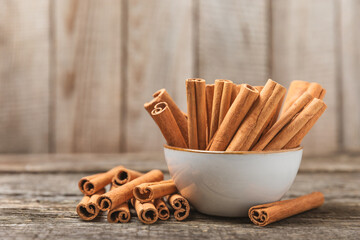Cinnamon sticks on a textured wooden background. Cinnamon roll. Spicy spice for baking, desserts and drinks. Fragrant ground cinnamon. cinnamon powder Close-up. Place for text. copy space