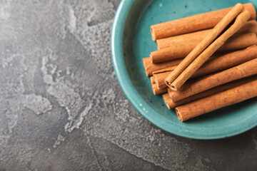 Cinnamon sticks on a textured wooden background. Cinnamon roll. Spicy spice for baking, desserts...