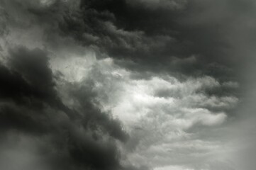A dark and stormy sky with a hint of light breaking through the clouds.