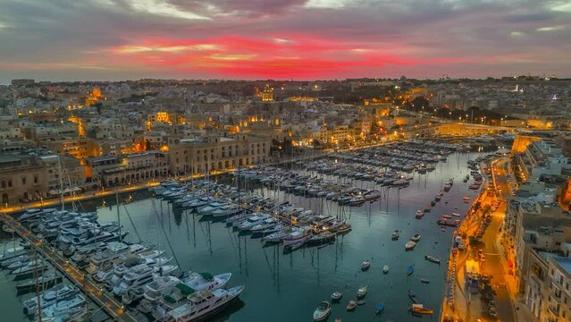 Aerial sunrise view of three cities - Vittoriosa, Senglea and Cospicua - Malta. Epic evening shot of old town with churches and marina with yacht in Malta 