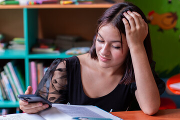 lifestyle: teenager distracted by his smartphone while studying