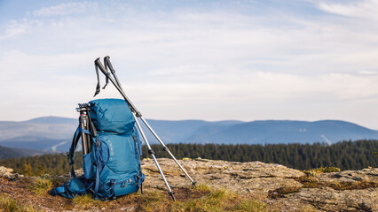 Backpack with tripod and hiking pole during trekking in mountains. Outdoor equipment for hike and trekking activity