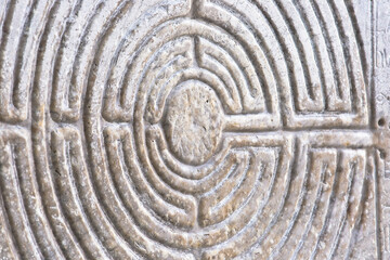 Labyrinth carved on the stone facade of a Romanesque church of the 11th century (Tuscany - Italy)