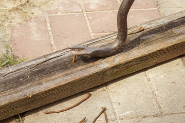 Pulling a nail out of a board using a nail puller.