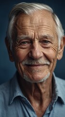 Obraz premium The gray-haired elderly man smiles happily. Indigo background.
