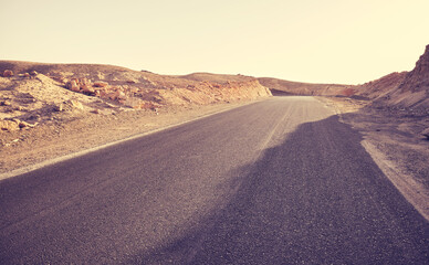 Desert road, front focus on asphalt, travel concept, color toning applied, Egypt.