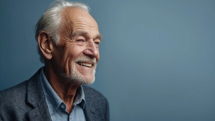 Obraz premium The gray-haired elderly man smiles happily. Indigo background.