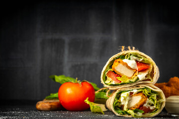 Fried chicken wraps with nuggets, fresh vegetables and buttermilk ranch sauce, healthy balanced street fast food, copy space