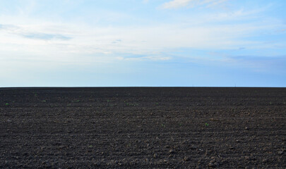 a plowed field with horizon line in the dusk copy space 