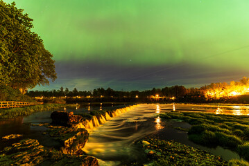 Aurora borealis, The Northern lights over Venta waterfall. Kuldiga, Latvia.