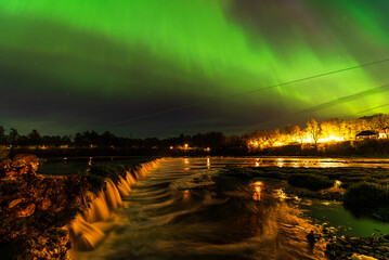 Aurora borealis, The Northern lights over Venta waterfall. Kuldiga, Latvia.