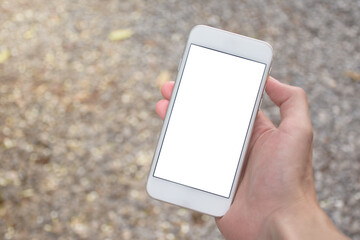Close up of man hand holding modern smartphone mockup with blank white screen. Hand showing white screen of smartphone in ground blurred background.