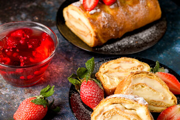 Sliced rolls with custard. The dessert is decorated with fresh strawberries