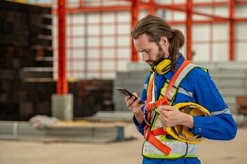 construction worker use smartphone cellphone in factory