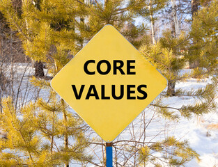 Core values symbol. Concept words Core values on beautiful yellow road sign. Beautiful forest snow...