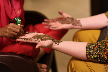Women Drawing Henna on Women's Hand, Mehndi Design in Wedding Ceremony Closeup | Henna Hand Desing