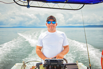 Man captain driving boat on ocean tour