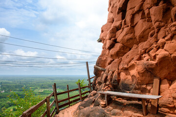 Bench on the edge of a beautiful orange rock cliff at the top of a mountain with a view of nature and the morning sky. Beautiful landscape of sky rock mountain are amazing scenery of Thailand.