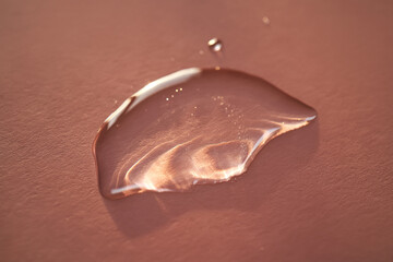 Beautiful volumetric drop of cosmetic product on a pink background.