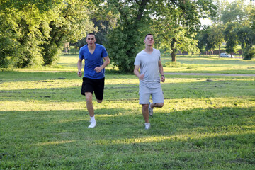 Two young and handsome teenagers is jogging in the public park