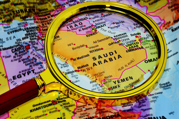 Fototapeta premium Map Saudi Arabia under magnifying glass, loupe. Kingdom of Saudi Arabia on the World Map