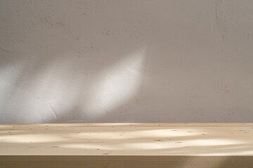 Wooden table mockup on stucco background with abstract sun light reflections on the wall. Mock up...