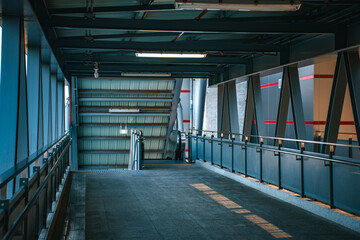 The walkway bridge built with modern steel architecture connects to the capital's electric train station which is decorated with lights and escalators.