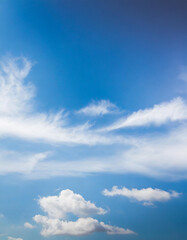 Blue sky background with white clouds. Cumulus and stratus white clouds in the blue sky.