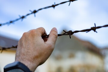 Hand and barbed wire. Violation of the law on the departure of citizens from Ukraine	