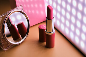 Creative photo of open pink lipstick in the dark