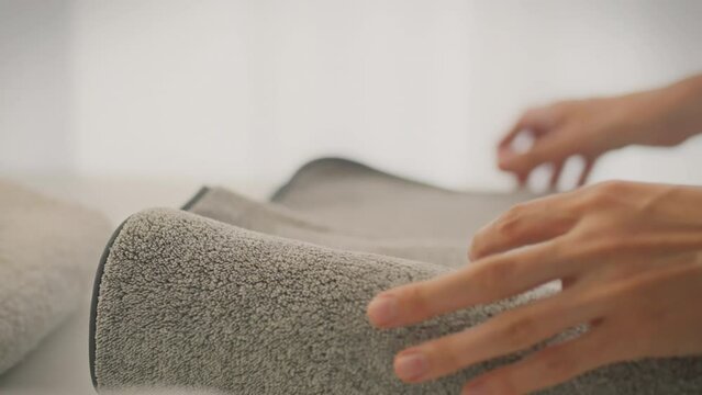 The modern housewife carefully puts away a stack of clothes, showing concern for order in the house. She ensures cleanliness by folding washed and dried items, not forgetting about fresh towels.