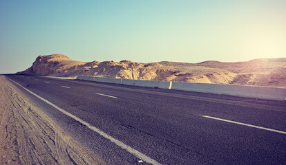 Desert road at sunset, color toning applied, Egypt.