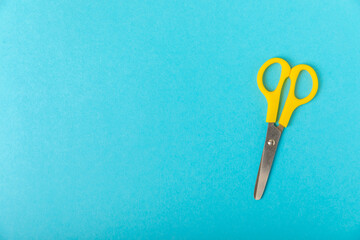 Bright children's scissors on a colored paper background. Stationery. Goods for school. Place for text. Copy space.Top view