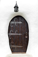 Enchanted Entryway: Mystical Arched Door in old Cottage. Charming arched wooden door set in quaint...