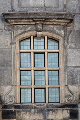 Fototapeta premium Window of the old Lutheran church Kreuzkirche against the background of a stone wall in the city of Dresden. From the Window of the World series.