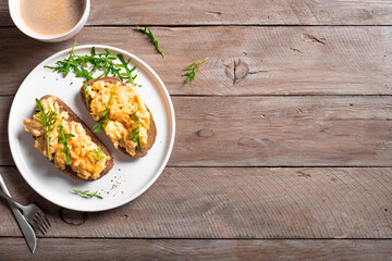 Scrambled eggs sandwiches with arugula microgreens