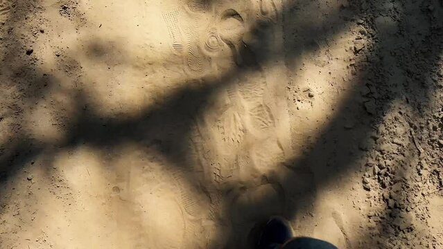 Slow motion phootage of human walking on the sand in the desert with his snickers