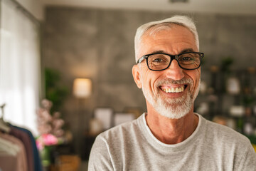 Obraz premium Portrait of one mature senior caucasian man stand and smile at home