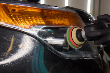 Person using a machine to polish automotive lighting on a car headlight