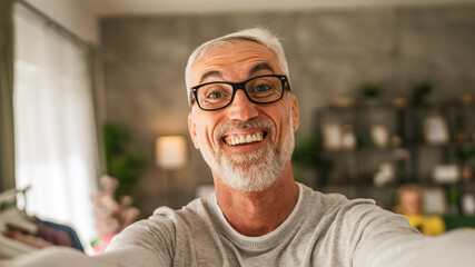 One mature man hold mobile phone and do self portrait of himself