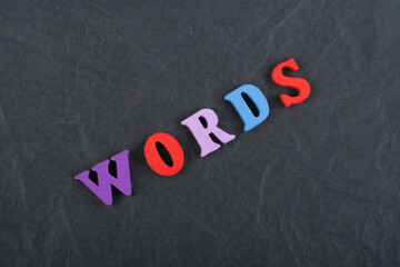 Words letters on black board background composed from colorful abc alphabet block wooden letters, copy space for ad text. Learning english concept.