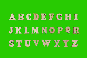 wooden letters of the English alphabet on a green background