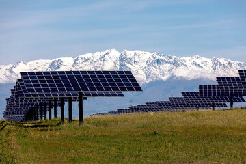 Solar Panels in Front of Snowy Mountain Range