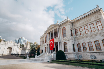 Obraz premium Dolmabahce sarayi palace in Besiktas Istanbul. Fasade with national turkish flag.