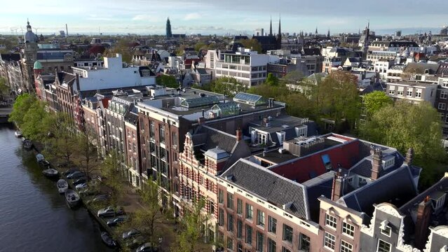 Historical Center of Amsterdam, Netherlands. Aerial Drone Shot of Traditional Dutch houses on narrow street and channel.