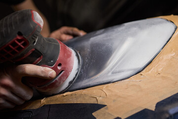 Person using a machine to polish automotive lighting on a car headlight